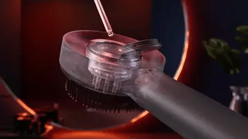Close up of a NUE scalp brush with a dark background