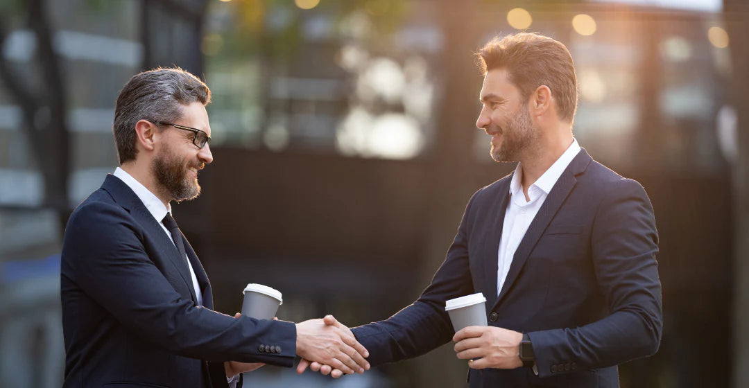 Two businessmen shaking hands outdoors for Nue business cllaboration