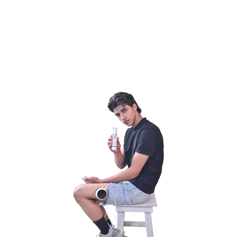 Person sitting on a stool holding a NUE Therapy Oil.